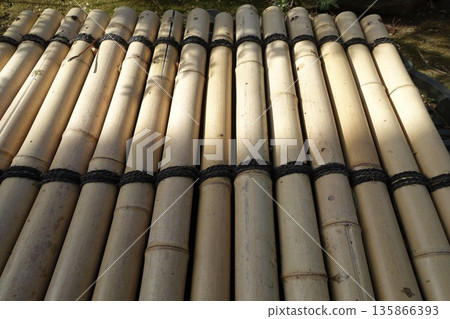 Light shining on a bamboo well cover 135866393