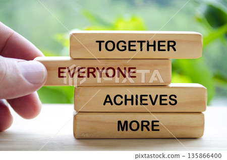 Togetherness and team success concept using wooden blocks to communicate unity collaboration and shared goals. 135866400