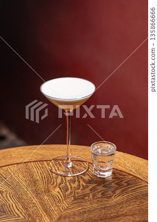 Sour style cocktail with foam and side shot 135866666