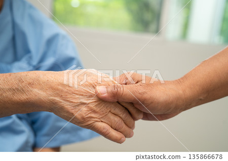 Caregiver holding hands Asian elderly woman patient, help and care in hospital. Caregiver holding hands Asian elderly woman patient, help and care in hospital. 135866678