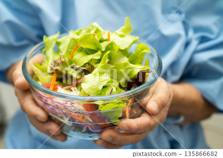 Asian Nutritionist holding salad vegetable healthy food for patient, nutrition and vitamin. 135866682