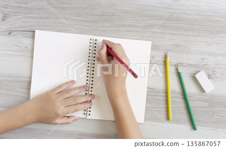 孩子在筆記本上寫字或畫畫 孩子在筆記本上寫字或畫畫 135867057