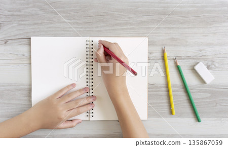A child writing or drawing in a notebook 135867059