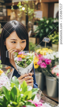 Smiling Japanese woman holding a bouquet at a flower shop 135867217
