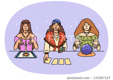 Female fortune tellers use tarot cards and oracle crystal ball to predict future 135867327