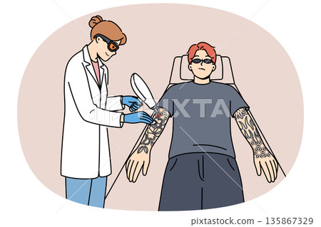 Procedure for laser tattoo removal from guy arms, with professional woman doctor. Procedure for laser tattoo removal from guy arms, with professional woman doctor. 135867329