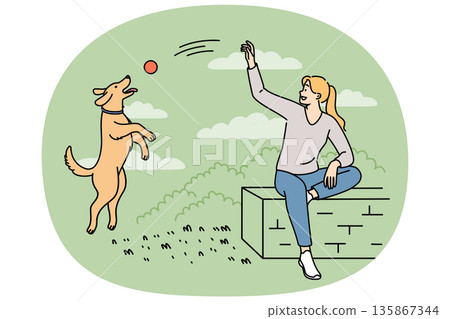 Woman plays with dog in park, tossing ball to bouncing puppy and enjoying perfect sunny weather 135867344