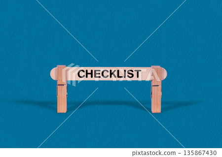 Checklist symbol. Single Wooden stick confined by  Clothespins, Cool Blue Background. Business and Checklist concept with copy space 135867430