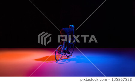 High performance cycling athlete in dynamic neon studio scene. High performance cycling athlete in dynamic neon studio scene. 135867558