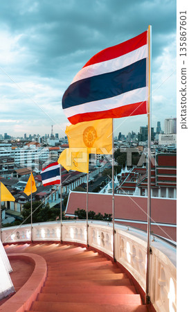 Thai flag waving over Bangkok city skyline with temples, Thailand national flag against urban panorama grand palace view Thai flag waving over Bangkok city skyline with temples, Thailand national flag against urban panorama grand palace view 135867601