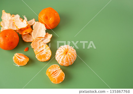Organic oranges and sweet peeled segments on minimal background Organic oranges and sweet peeled segments on minimal background 135867768
