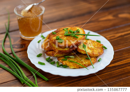 Crispy potato fritters served warm on rustic background 135867777