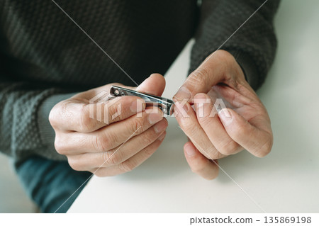 nail trimming seated at a table nail trimming seated at a table 135869198