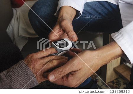 a healthcare worker checks oxygen saturation 135869213