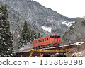This is a local train on the Bantan Line, operated in the JNR livery of a Kiha 41, running through the snow-covered mountains. 135869398