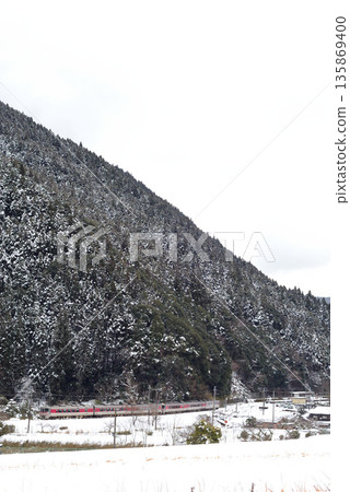 This is the Hamakaze limited express train running on the Bantan Line, a local line through the snow-covered mountains. 135869400