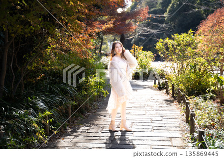 Woman in autumn park 135869445