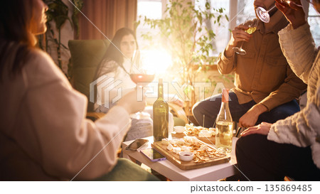 Group enjoying wine tasting with bottles and snacks at home Group enjoying wine tasting with bottles and snacks at home 135869485