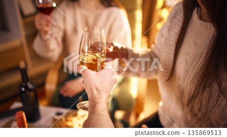 Friends clinking wine glasses during home wine tasting 135869513