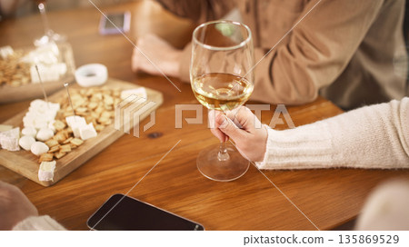 Close up of white wine glass during social tasting event. 135869529