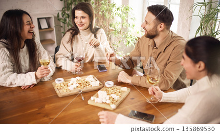 Friends drinking wine together at home table setting. Friends drinking wine together at home table setting. 135869530