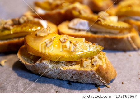 Pear bruschetta with white cheese and walnuts Pear bruschetta with white cheese and walnuts 135869667