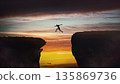 Determined man jumping over a chasm to reach the other side. Conceptual scene for overcoming obstacles and reaching new highs. Motivational and inspirational background 135869736