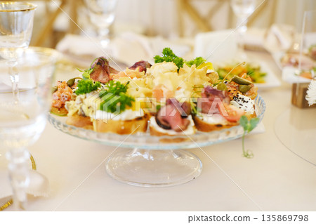 Colorful assortment of gourmet appetizers arranged on a glass platter, featuring fresh ingredients and elegant presentation, ideal for catering events and celebrations Colorful assortment of gourmet appetizers arranged on a glass platter, featuring fresh ingredients and elegant presentation, ideal for catering events and celebrations 135869798