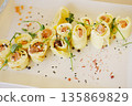 Delicious gourmet food presentation featuring rolled savory crepes filled with salmon, garnished with fresh herbs and spices, showcasing culinary artistry and vibrant colors 135869829