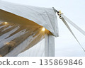 Tent securing process with straps and clips, ensuring stability and protection against wind, showcasing durable materials and outdoor setup for events and gatherings with copy space 135869846