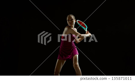 Professional female tennis player preparing backhand shot in studio. Professional female tennis player preparing backhand shot in studio. 135871011