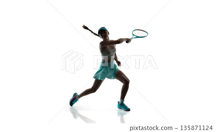 Professional female tennis player performing backhand stroke in studio. 135871124