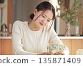 A young woman staring at her money and thinking about how to spend it 135871409