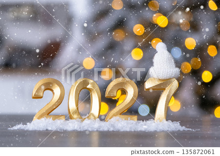 Golden figures number 2027 New Year against the background of fairy light, snow and garlands. Greeting card, Happy New Year, cozy home Golden figures number 2027 New Year against the background of fairy light, snow and garlands. Greeting card, Happy New Year, cozy home 135872061