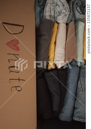 Box filled with neatly folded clothes ready for donation at a local charity for those in need Box filled with neatly folded clothes ready for donation at a local charity for those in need 135872237