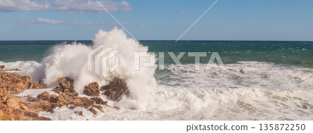 Stormy seascape with waves crashing against rocky shore and high white foam splashes. Stormy seascape with waves crashing against rocky shore and high white foam splashes. 135872250