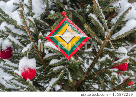 Red wool ball hanging on the green branches of a Christmas tree. Red wool ball hanging on the green branches of a Christmas tree. 135872259