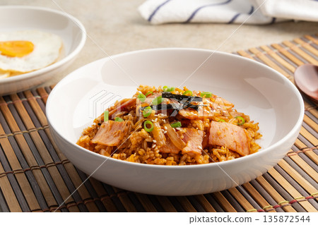 Kimchi fried rice with bacon topped with sesame seed and Crispy Seaweed in white plate.Korean food. 135872544