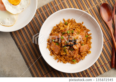 Kimchi fried rice with bacon topped with sesame seed and Crispy Seaweed in white plate.Korean food.Top view. 135872545