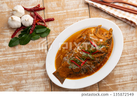 Tilapia Fish with red curry sauce,Thai Chu Chee Fish Curry in a plate. 135872549