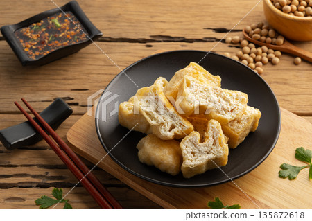 Deep fried tofu in black plate. 135872618