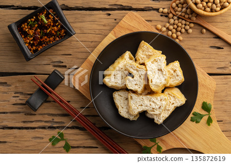 Deep fried tofu in black plate. 135872619