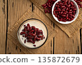 Boiled red beans in coconut milk and sugar in glass bowl,Thai Dessert on wooden table.Top view. 135872679