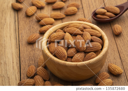 Dry roasted Almonds in wooden bowl on wooden table.Heap of almond. Dry roasted Almonds in wooden bowl on wooden table.Heap of almond. 135872680