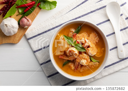 Red curry Pineapple and shrimp in white bowl.(Kang Kua Subpharod Kung) Thai food.Top view. 135872682