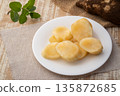 Close up peeled Yacon root fruit(Smallanthus sonchifolius) in white plate on wooden table. 135872685