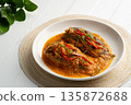Fish with Red Curry Sauce,Thai food,Climbing gourami fish in Dried spicy curry paste mix with coconut milk in white plate 135872688