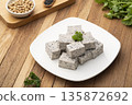 Sliced piece of Tofu mix black sesame seeds in white plate on wooden table 135872692