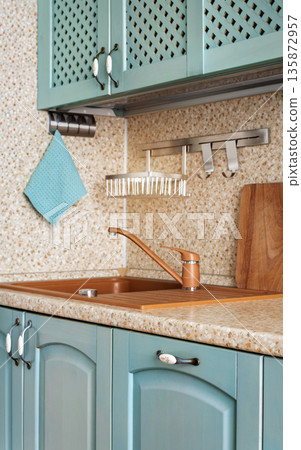 Cozy kitchen sink corner with countertop and cabinets 135872957