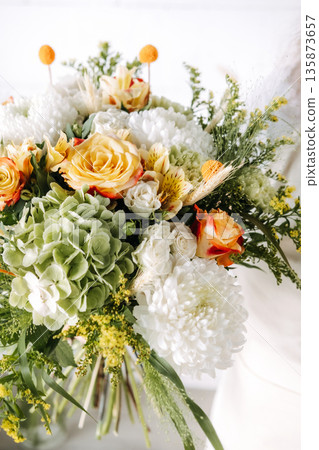 Floral bouquet features roses and hydrangeas with mixed seasonal greenery. Sustainable floristry, locally grown flowers, artisanal bouquet composition. Floral bouquet features roses and hydrangeas with mixed seasonal greenery. Sustainable floristry, locally grown flowers, artisanal bouquet composition. 135873657